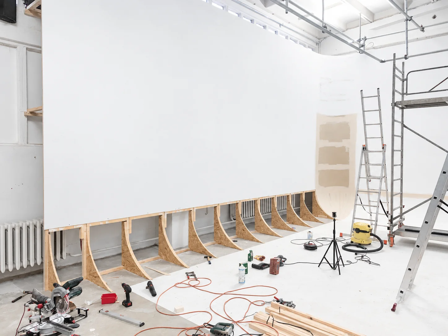 Baustelle mit Rigipsplatten, mit Werkzeugen für weiße Hohlkehle in Fotostudio.
